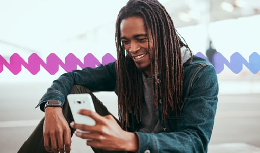 Knowledge AI Man sitting and smiling while using his mobile device