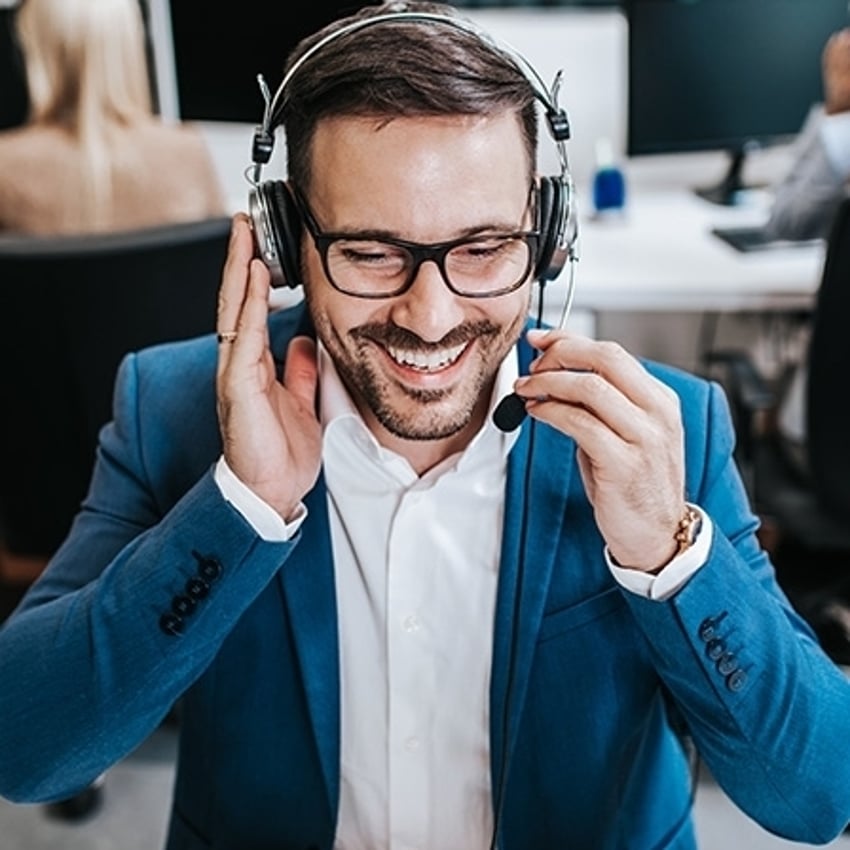 Agente de atendimento ao cliente masculino bonito, trabalhando em um escritório de call center como operador de telemarketing.